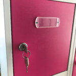 Cerradura de llave con dos llaves y portaetiquetas en puerta de taquilla metálica fucsia