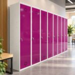 Fila de taquillas metálicas Basic de 1 puerta en magenta con estructura blanca, en un vestuario