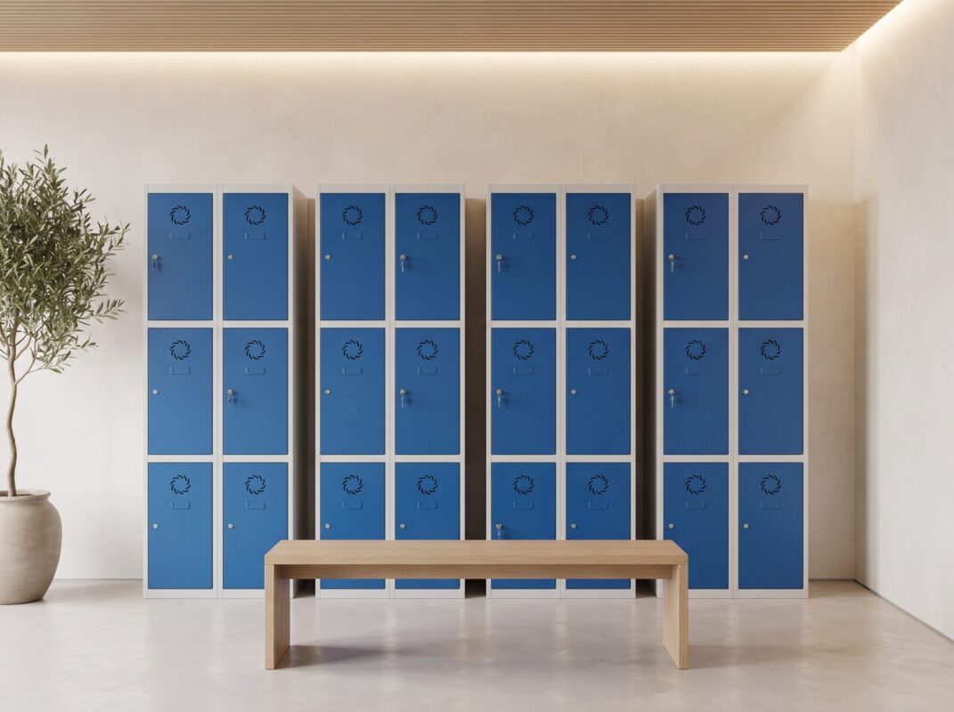 Taquillas metálicas con puertas azules y banco de madera en la zona de taquillas de una oficina Taquillas metálicas con puertas azules y banco de madera en la zona de taquillas de una oficina