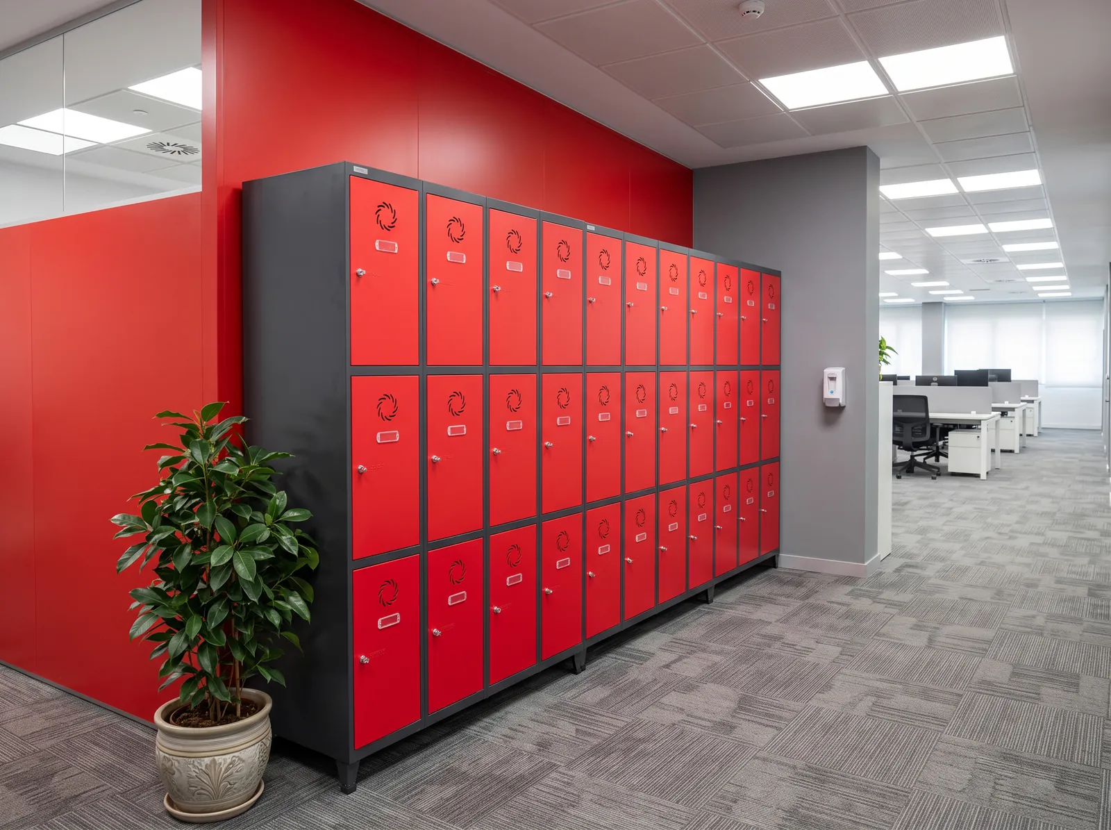 Taquillas metálicas para oficinas y empresas Kaitrax Taquillas metálicas de 3 puertas en rojo y antracita instaladas en una oficina como taquillas de personal